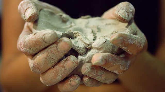 Hands holding clay to be sculpted